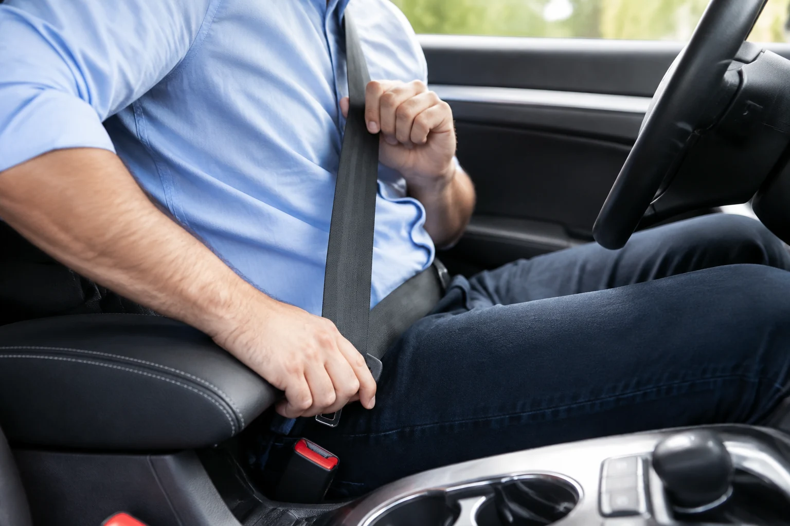 Close-up lifestyle image of driver fastening seat belt in a modern vehicle interior